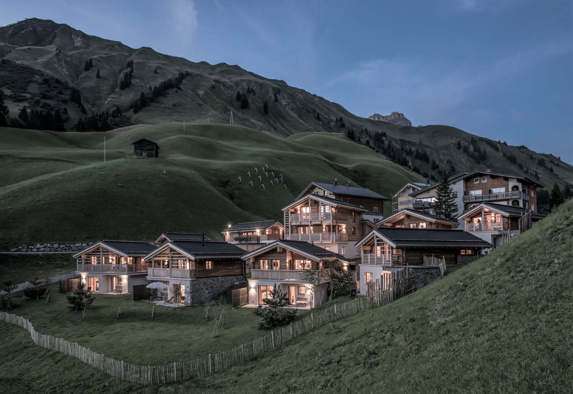 Chalets mit leuchtenden Fenstern in Dämmerung